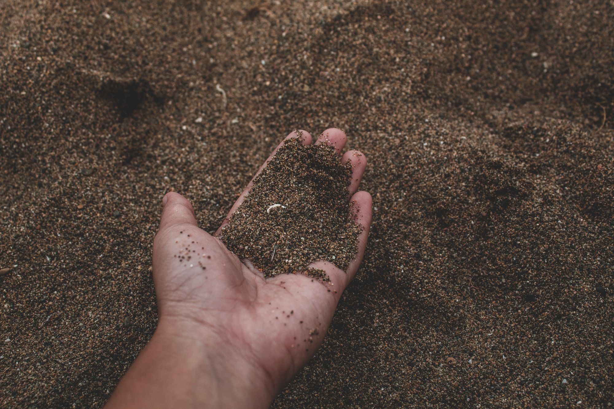 Une main qui recueille du sable